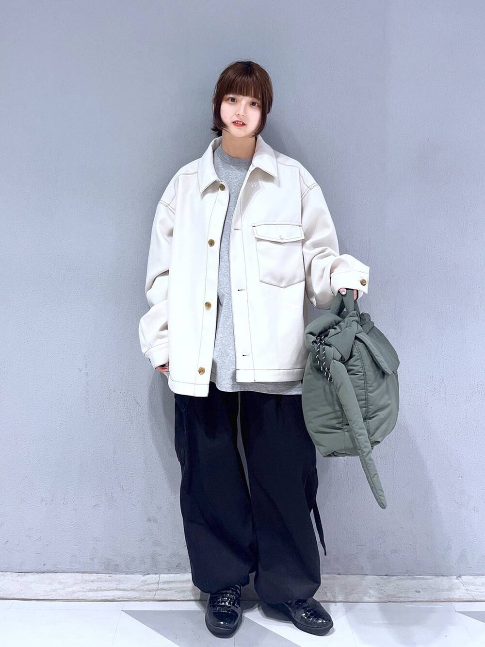 グレー系のTシャツ/カットソー、ブラック系のカーゴパンツ、グリーン系のショルダーバッグを着用したレディースの冬コーディネートの2枚目の写真