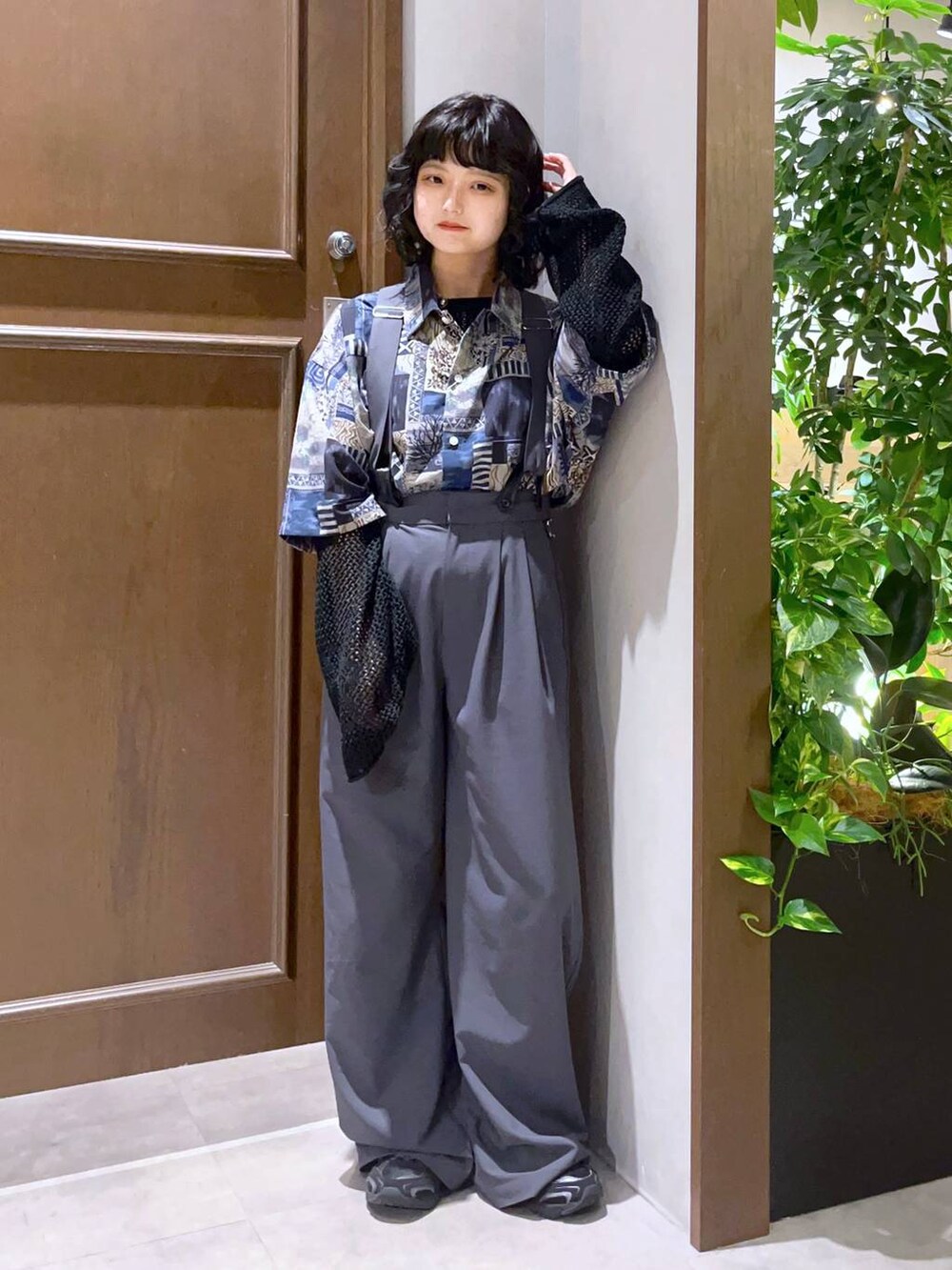 ブルー系のシャツ/ブラウス、グレー系のスラックス、ブラック系のニット/セーターを着用したレディースの春コーディネートの2枚目の写真