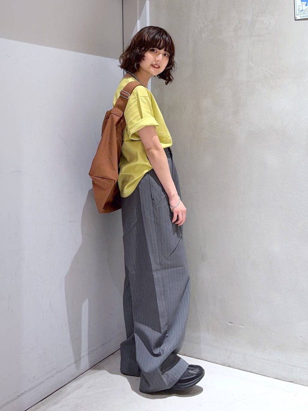 ブラック系のショルダーバッグ、グレー系のその他パンツ、イエロー系のTシャツ/カットソーを着用したレディースの夏コーディネートの3枚目の写真