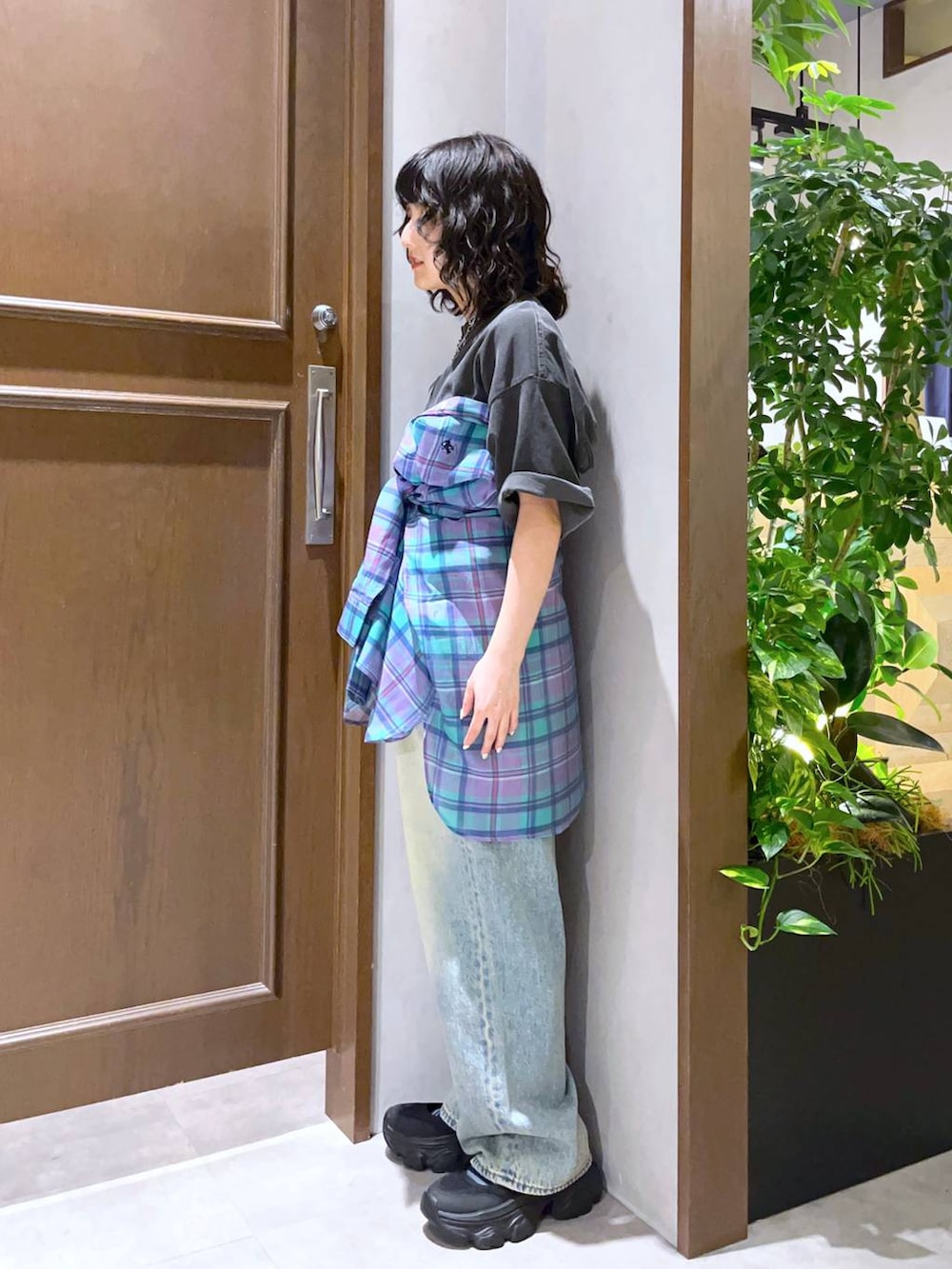 ブルー系のデニムパンツ、ブラック系のサンダル、ブラック系のTシャツ/カットソーを着用したレディースの春コーディネートの3枚目の写真