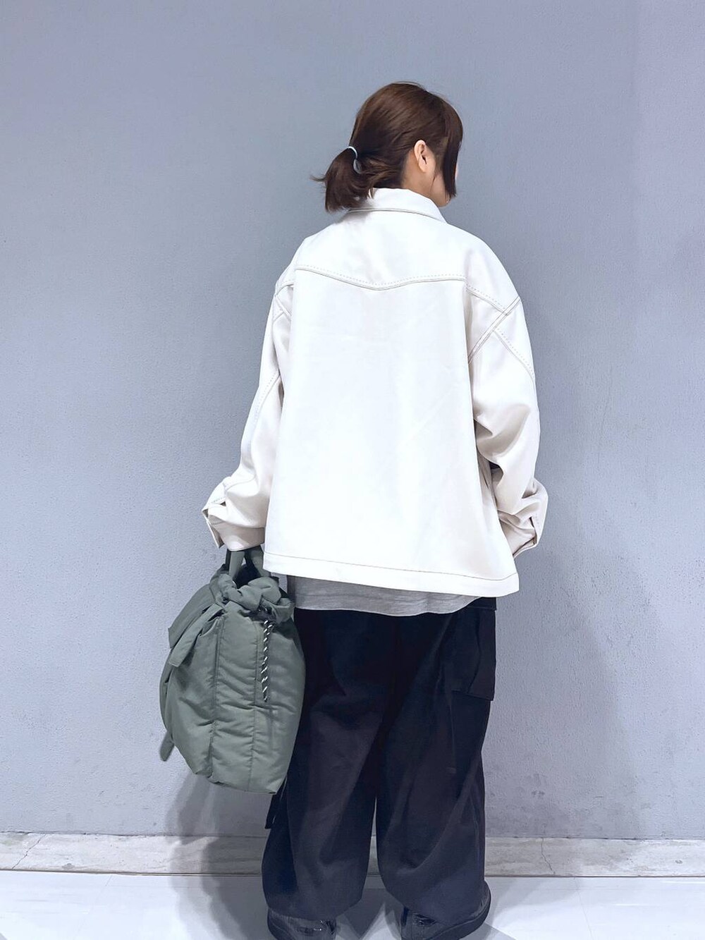 グレー系のTシャツ/カットソー、ブラック系のカーゴパンツ、グリーン系のショルダーバッグを着用したレディースの冬コーディネートの4枚目の写真