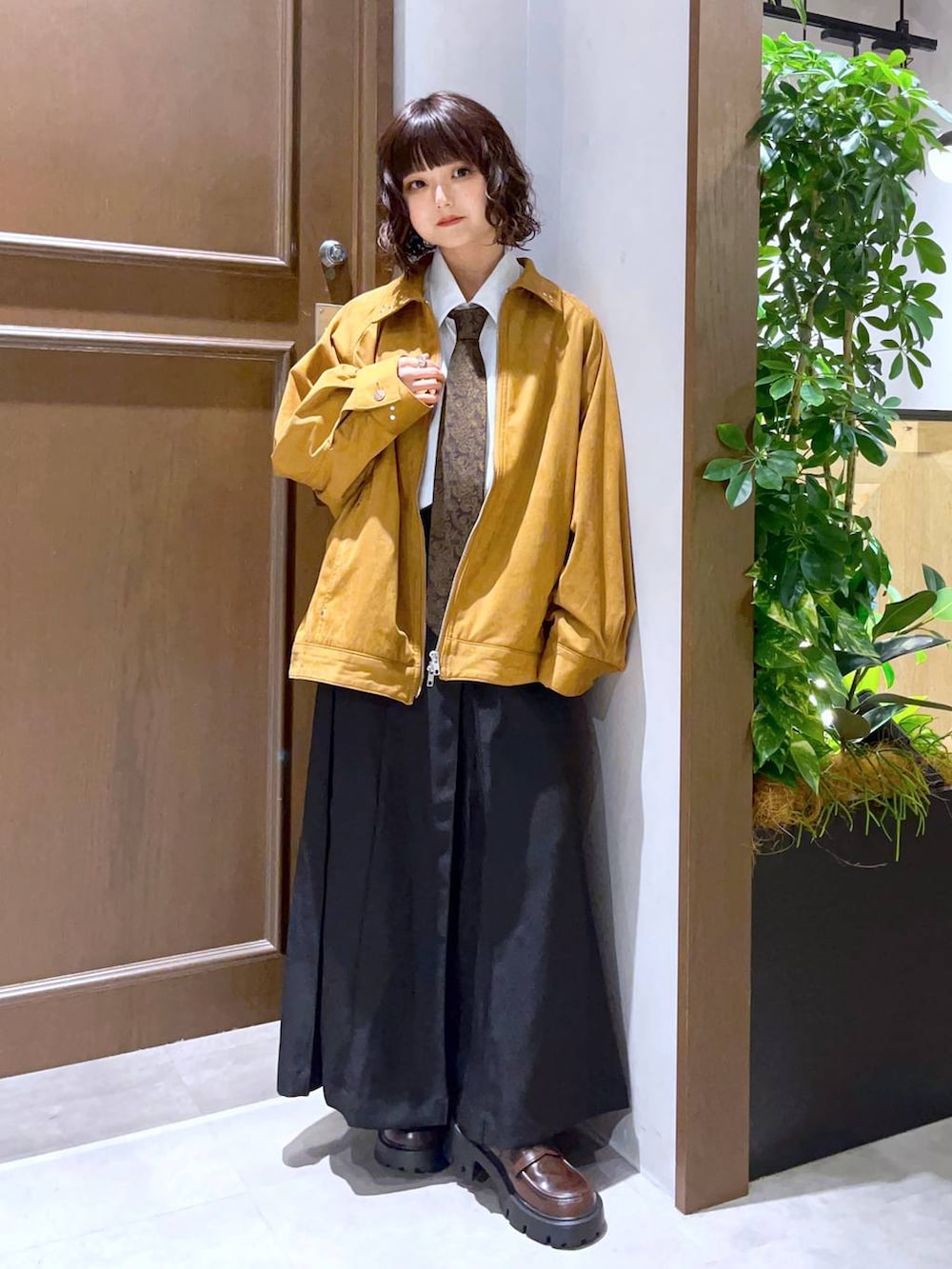 ホワイト系のシャツ/ブラウス、ブラック系のスカート、ブラウン系のブルゾンを着用したレディースの秋コーディネートの3枚目の写真