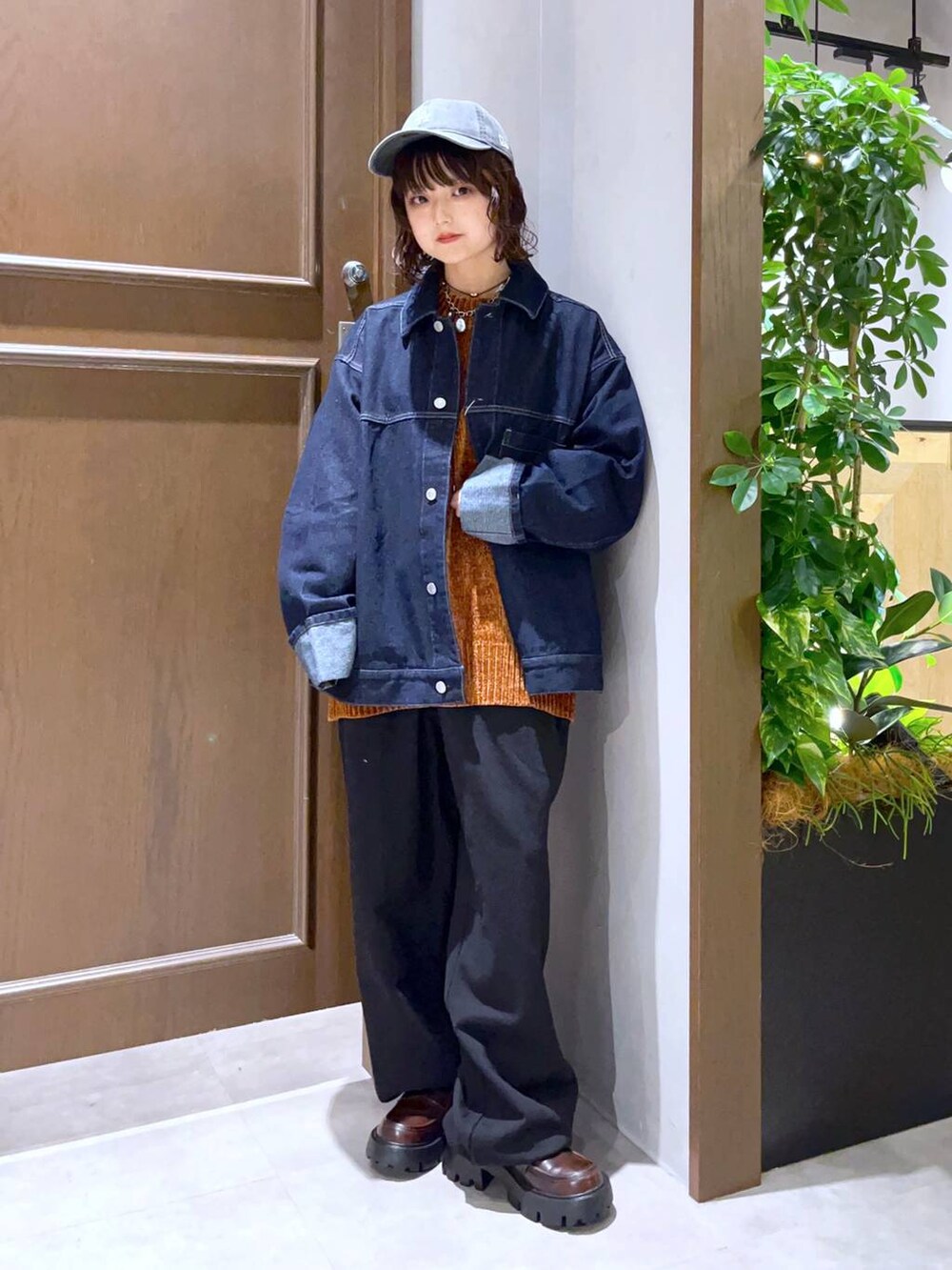 ブルー系のデニムジャケット、ブラウン系のTシャツ/カットソー、ブラック系のスウェットパンツを着用したレディースの秋コーディネートの2枚目の写真