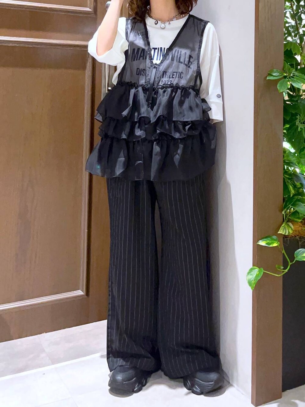 ブラック系のサンダル、ブラック系のスラックス、ホワイト系のTシャツ/カットソーを着用したレディースの夏コーディネートの5枚目の写真