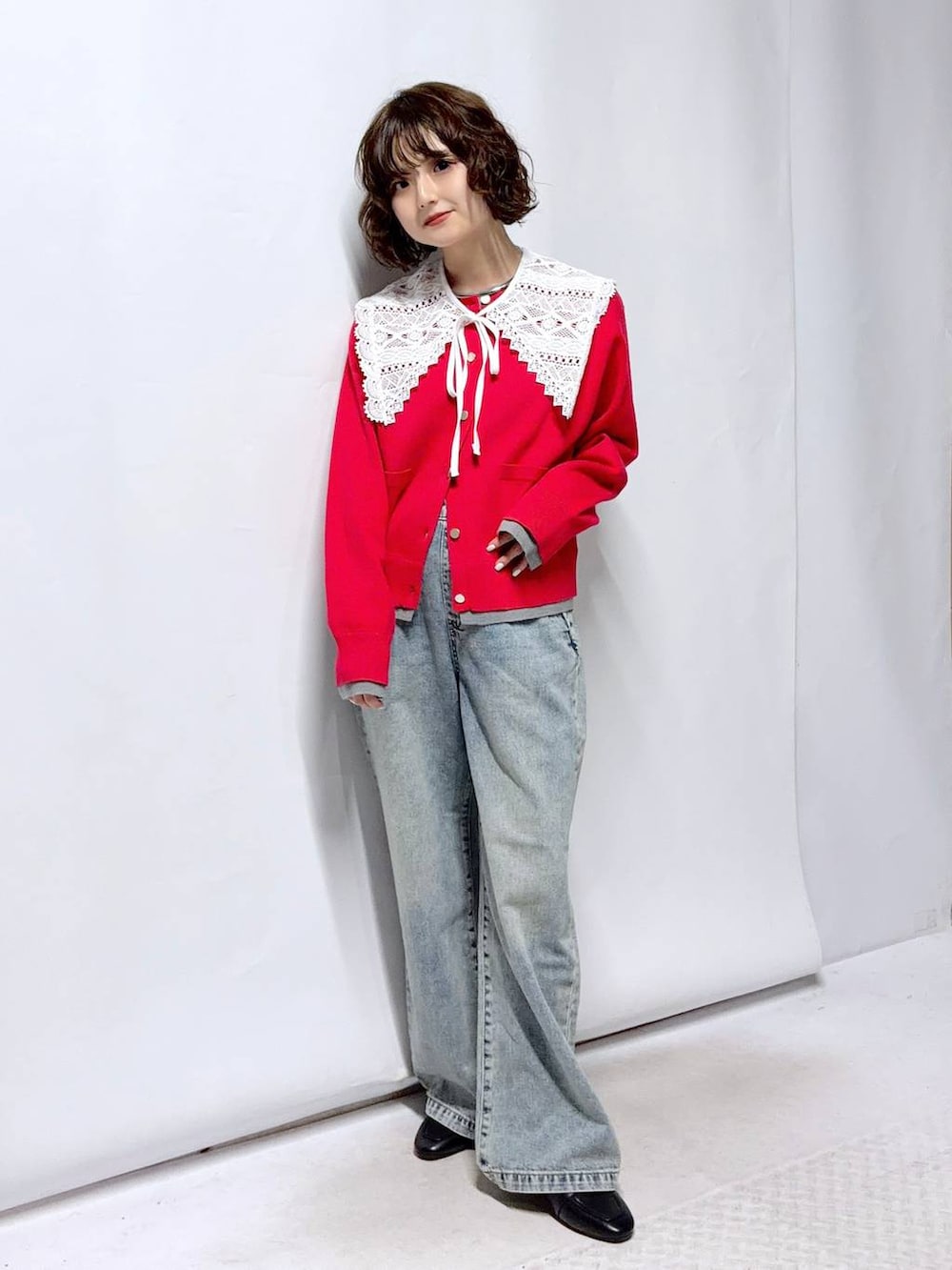 ブラック系のローファー、ブルー系のデニムパンツ、レッド系のカーディガン/ボレロを着用したレディースの春コーディネートの2枚目の写真
