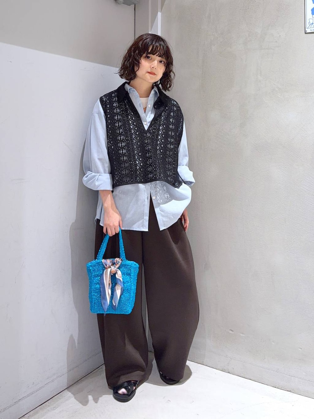 ブルー系のシャツ/ブラウス、ホワイト系のTシャツ/カットソー、ブルー系のクラッチバッグを着用したレディースの夏コーディネートの2枚目の写真