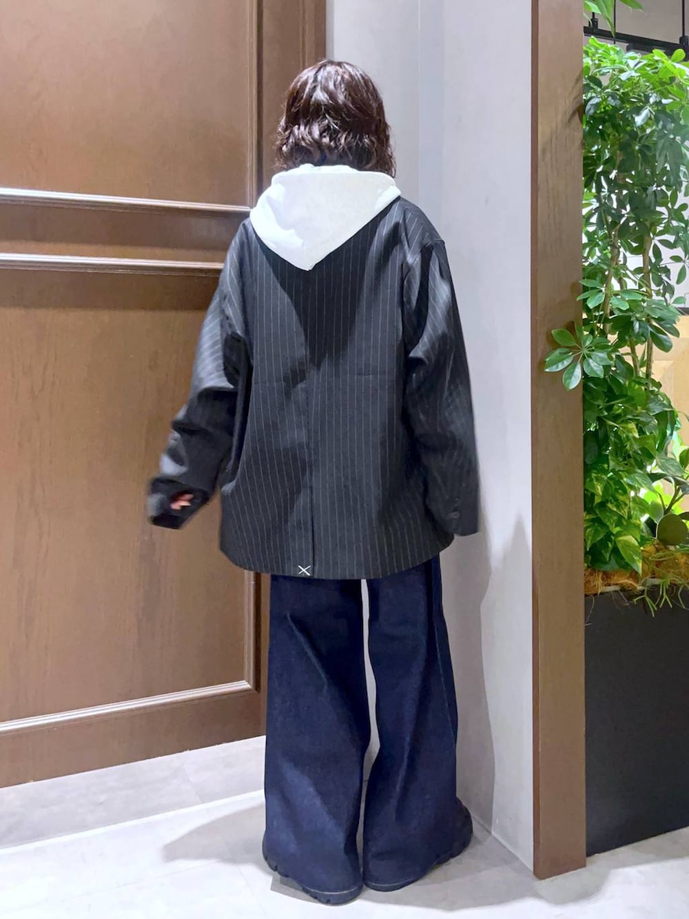 グレー系のシャツ/ブラウス、ブラウン系のローファー、ブルー系のデニムパンツを着用したレディースの秋コーディネートの3枚目の写真