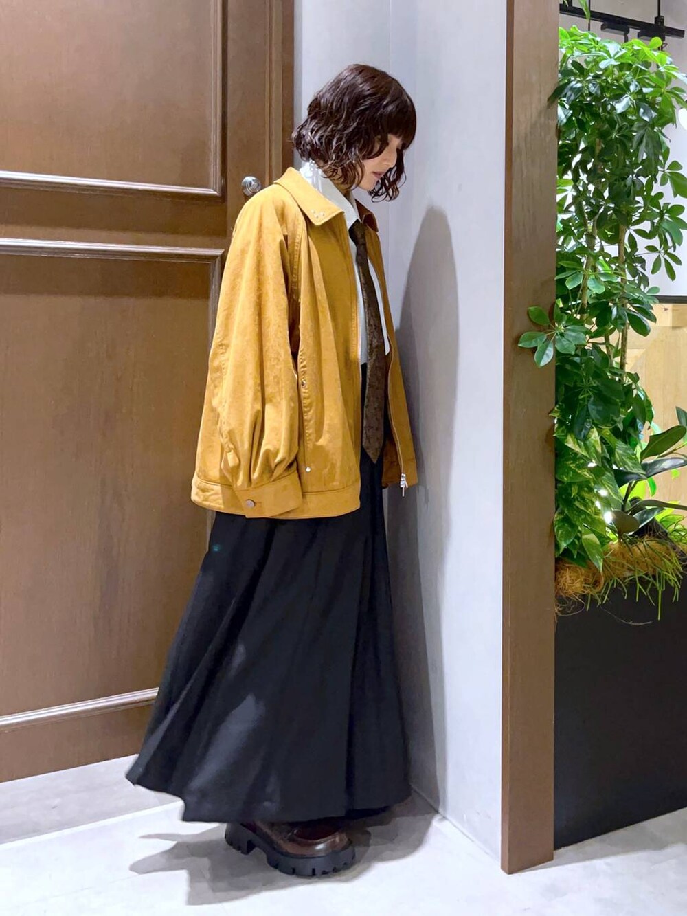 ホワイト系のシャツ/ブラウス、ブラック系のスカート、ブラウン系のブルゾンを着用したレディースの秋コーディネートの5枚目の写真