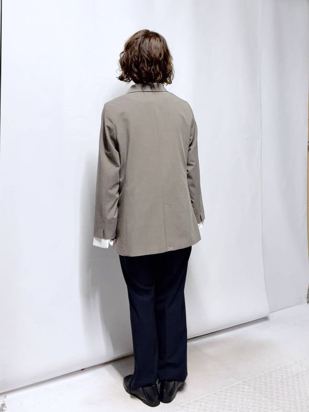 ブラック系のローファー、ブルー系のスラックス、ブラック系のセットアップを着用したレディースの冬コーディネートの4枚目の写真