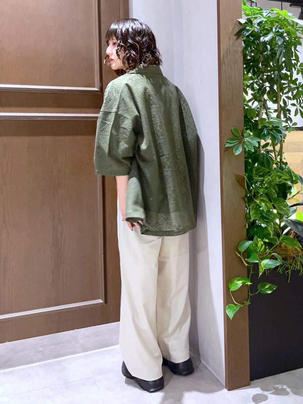 ホワイト系のスラックス、グリーン系のシャツ/ブラウス、ブラック系のTシャツ/カットソーを着用したレディースの夏コーディネートの5枚目の写真