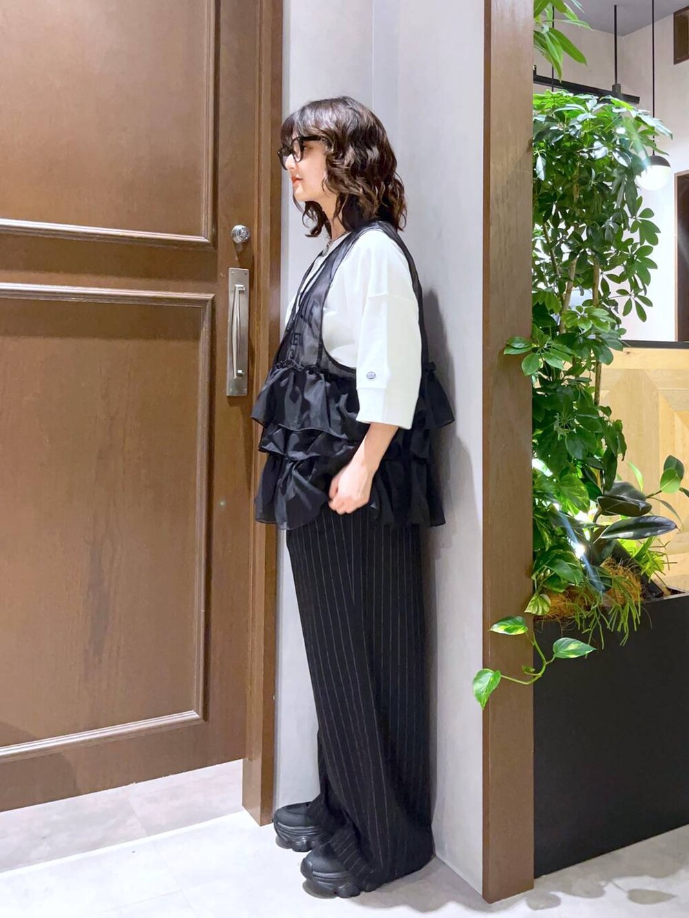 ブラック系のサンダル、ブラック系のスラックス、ホワイト系のTシャツ/カットソーを着用したレディースの夏コーディネートの3枚目の写真