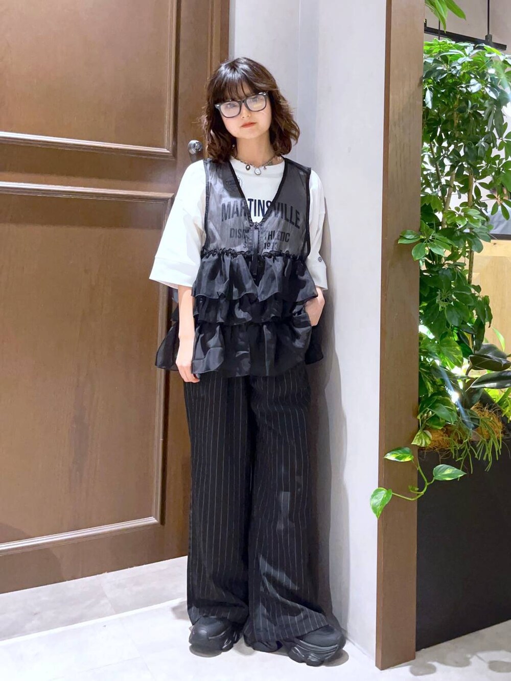 ブラック系のサンダル、ブラック系のスラックス、ホワイト系のTシャツ/カットソーを着用したレディースの夏コーディネートの2枚目の写真