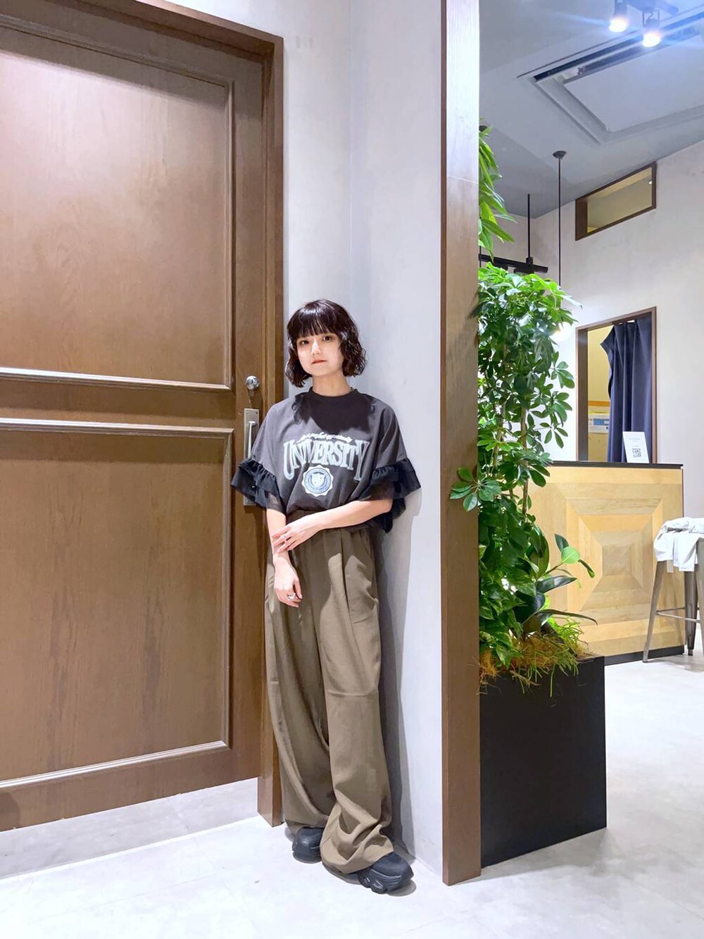 ブラック系のサンダル、ブラック系のTシャツ/カットソー、ブラウン系のスラックスを着用したレディースの夏コーディネートの5枚目の写真