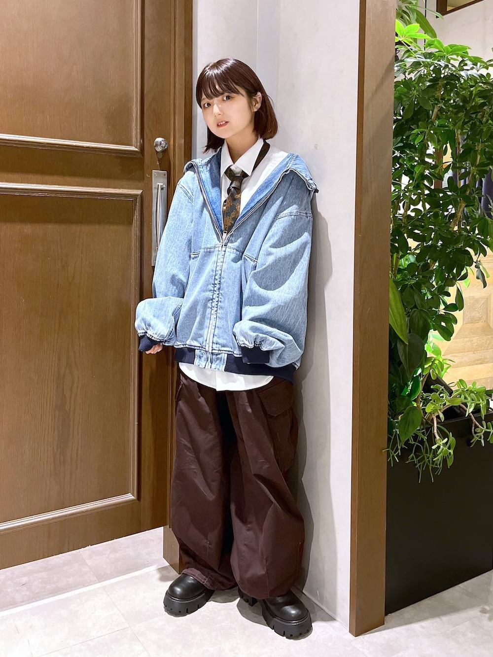 ブラウン系のカーゴパンツ、ホワイト系のシャツ/ブラウス、ブルー系のブルゾンを着用したレディースの秋コーディネートの2枚目の写真