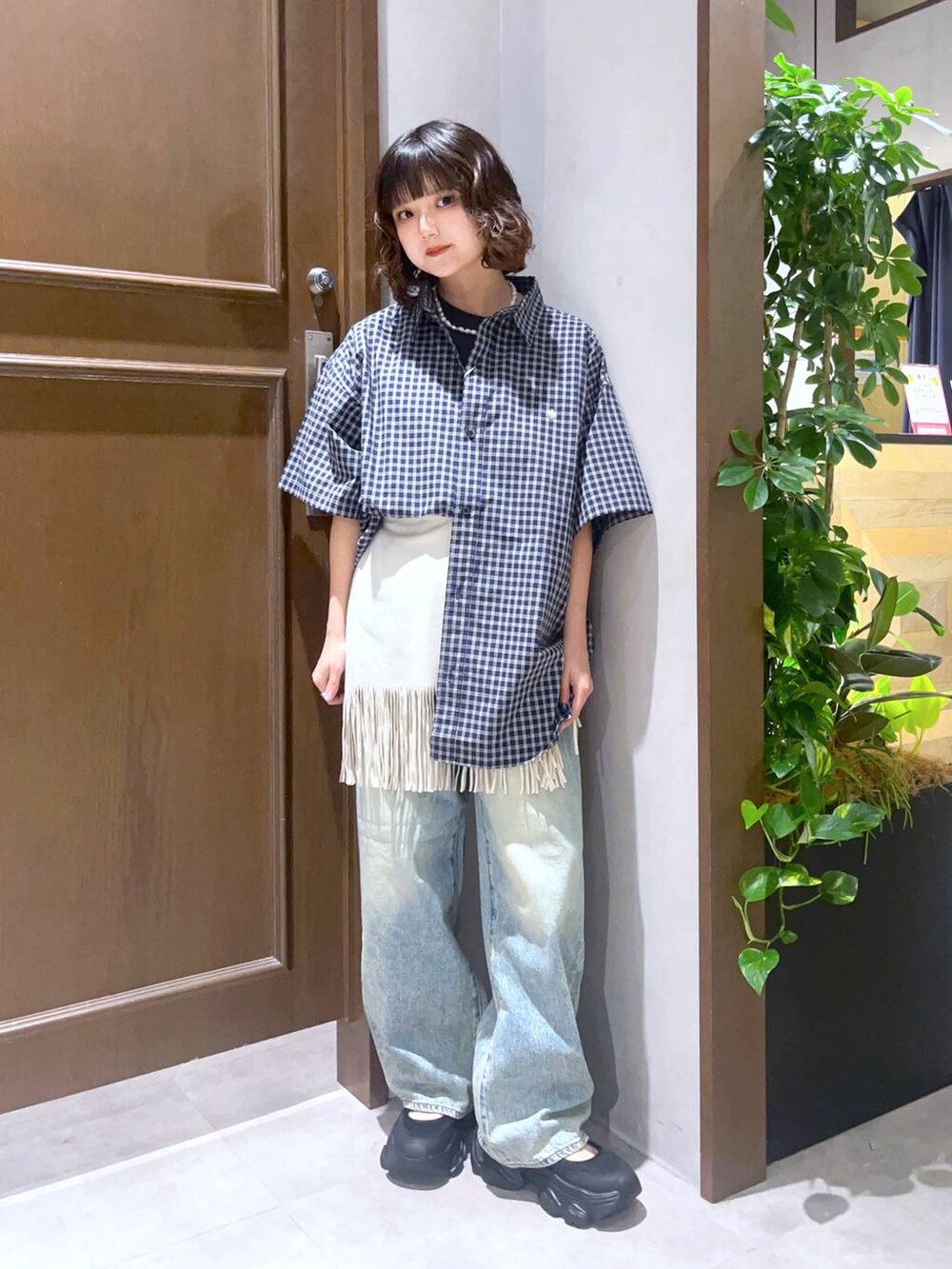 ブラック系のTシャツ/カットソー、ブラック系のサンダル、ホワイト系のスカートを着用したレディースの夏コーディネートの3枚目の写真