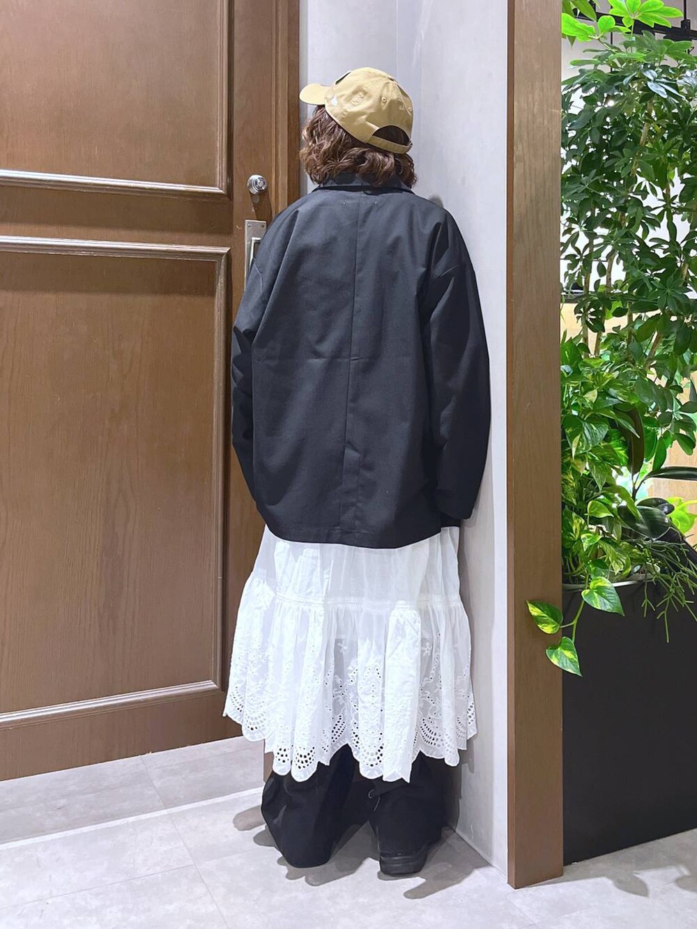 ブラック系のスラックス、ホワイト系のスカート、イエロー系のスウェットを着用したレディースの冬コーディネートの4枚目の写真