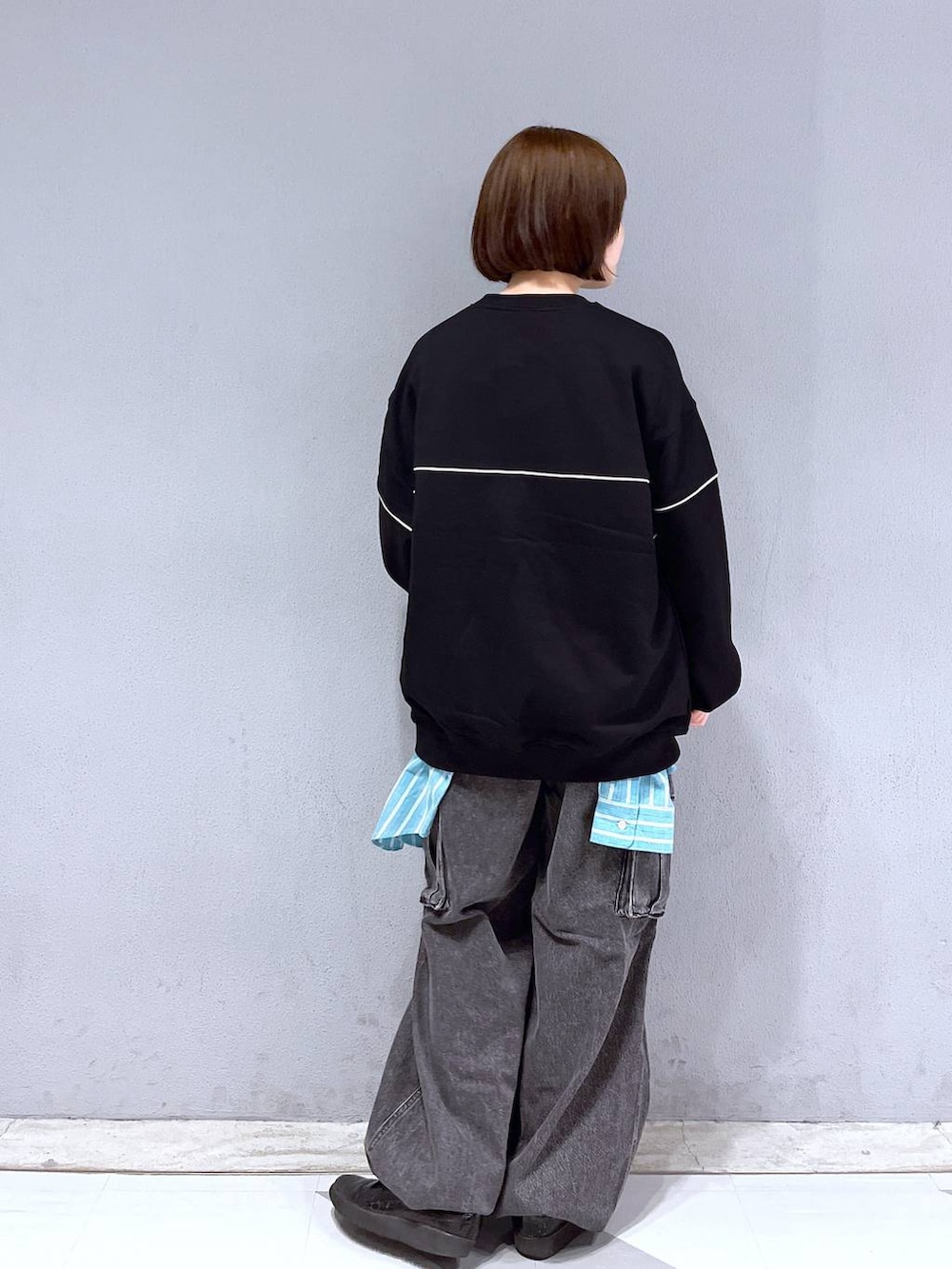 グレー系のデニムパンツ、ブラック系のスウェット、グリーン系のシャツ/ブラウスを着用したレディースの春コーディネートの4枚目の写真