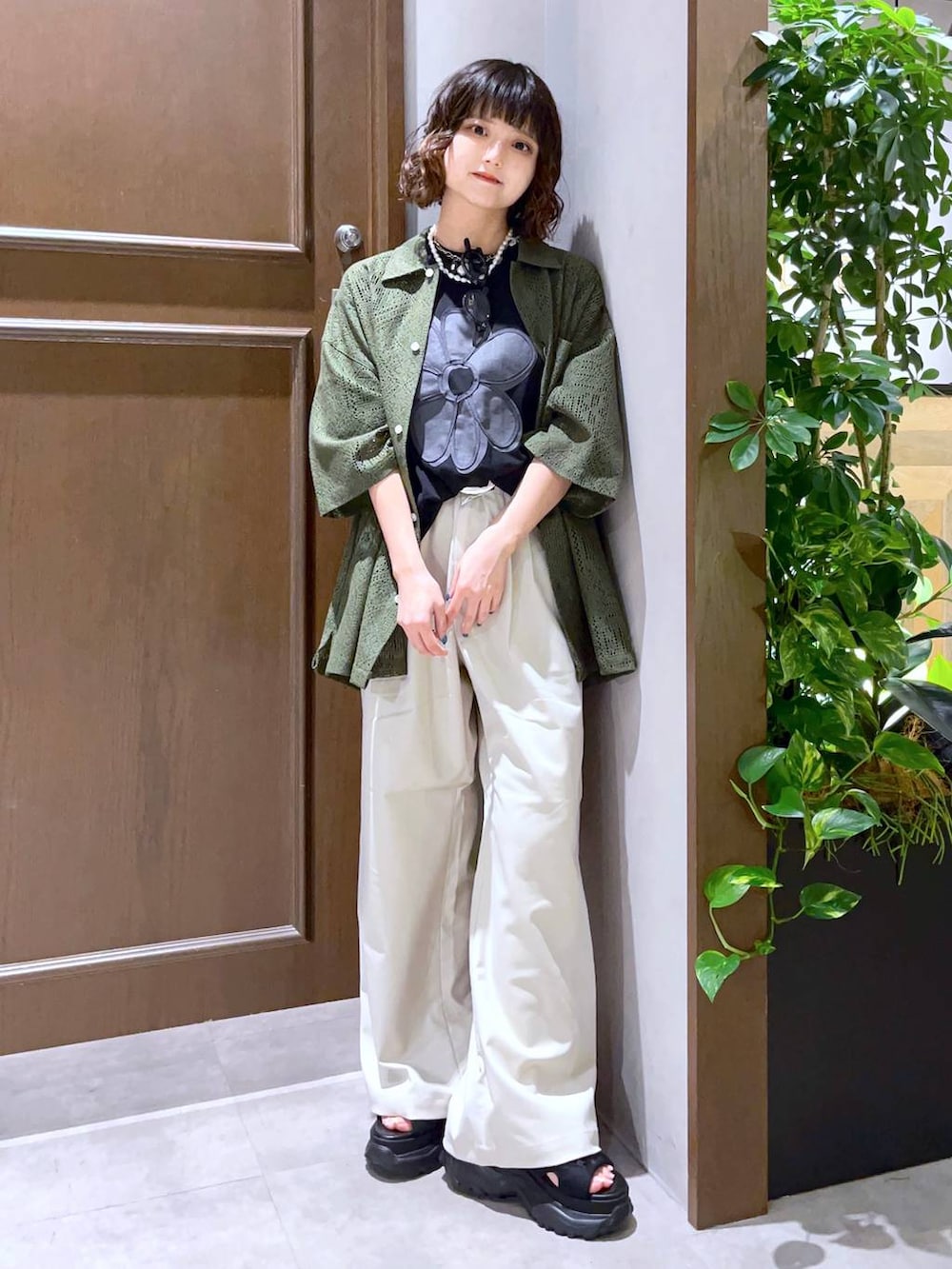 ホワイト系のスラックス、グリーン系のシャツ/ブラウス、ブラック系のTシャツ/カットソーを着用したレディースの夏コーディネートの6枚目の写真