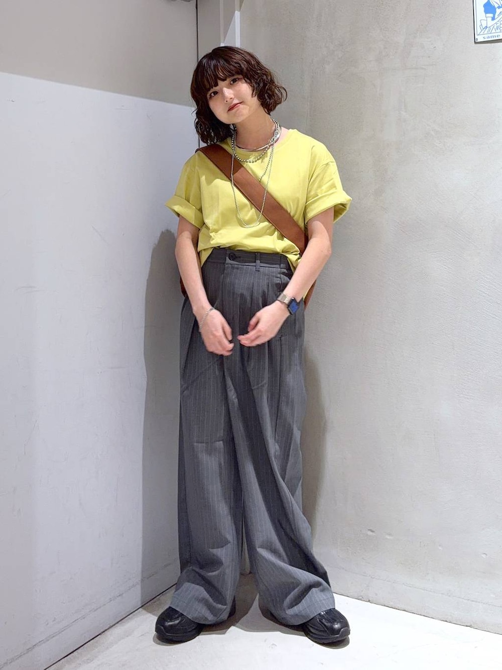 ブラック系のショルダーバッグ、グレー系のその他パンツ、イエロー系のTシャツ/カットソーを着用したレディースの夏コーディネートの2枚目の写真