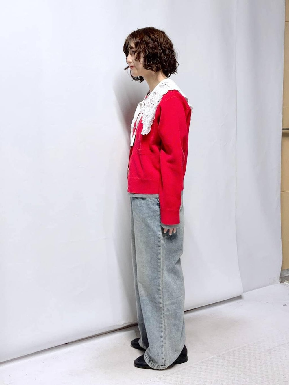 ブラック系のローファー、ブルー系のデニムパンツ、レッド系のカーディガン/ボレロを着用したレディースの春コーディネートの3枚目の写真