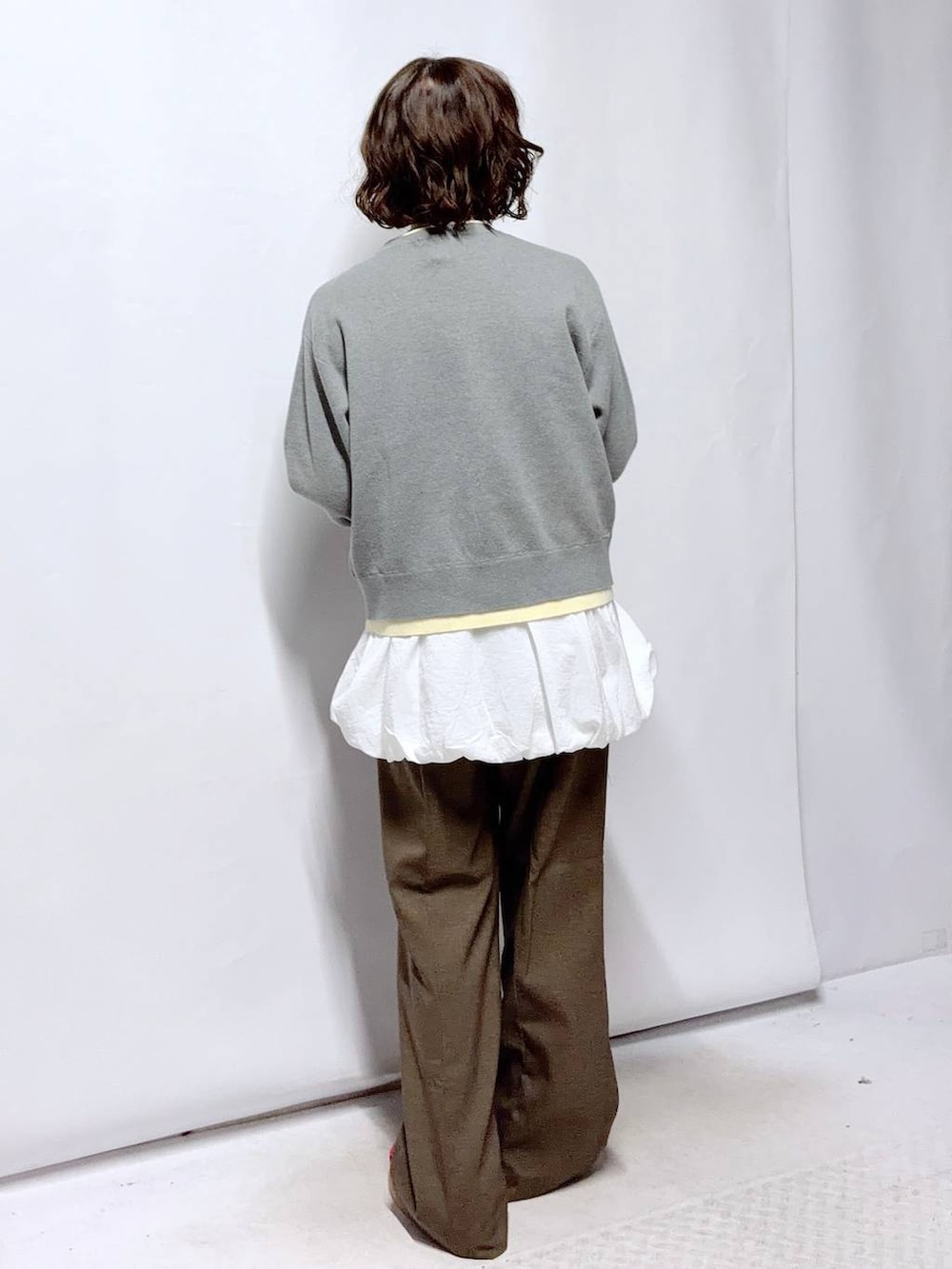 ブラウン系のその他パンツ、ホワイト系のTシャツ/カットソー、グレー系のカーディガン/ボレロを着用したレディースの冬コーディネートの4枚目の写真