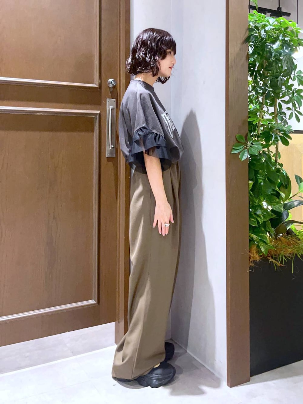 ブラック系のサンダル、ブラック系のTシャツ/カットソー、ブラウン系のスラックスを着用したレディースの夏コーディネートの3枚目の写真