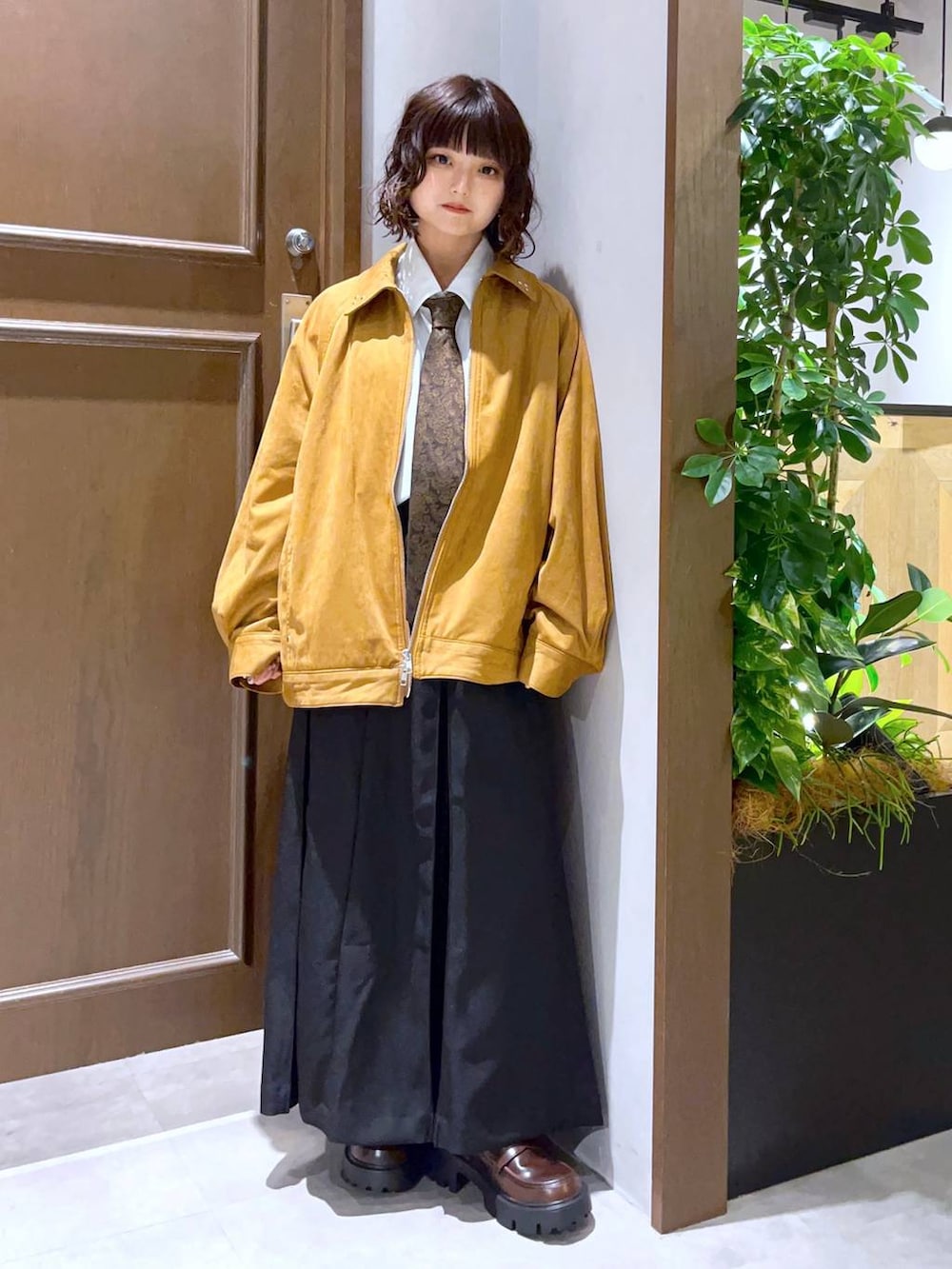 ホワイト系のシャツ/ブラウス、ブラック系のスカート、ブラウン系のブルゾンを着用したレディースの秋コーディネートの4枚目の写真