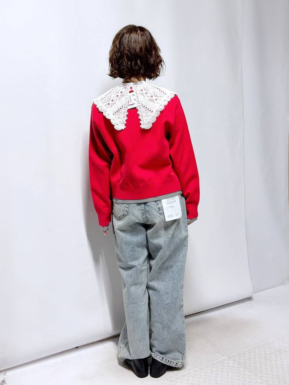 ブラック系のローファー、ブルー系のデニムパンツ、レッド系のカーディガン/ボレロを着用したレディースの春コーディネートの4枚目の写真