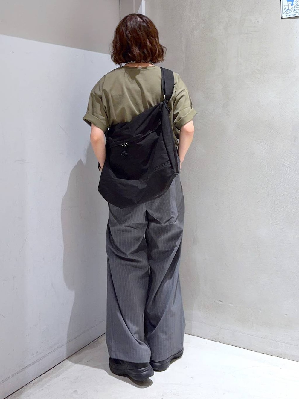 ブラック系のショルダーバッグ、グリーン系のTシャツ/カットソー、ブラック系のスニーカーを着用したレディースの夏コーディネートの5枚目の写真