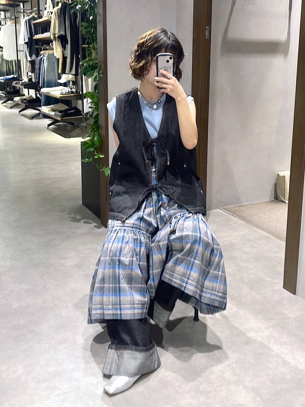 ブルー系のTシャツ/カットソー、ブラック系のベスト、ブルー系のスカートを着用したレディースの夏コーディネートの2枚目の写真