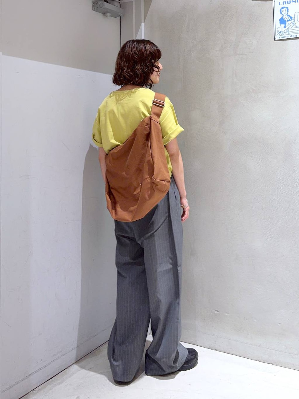 ブラック系のショルダーバッグ、グレー系のその他パンツ、イエロー系のTシャツ/カットソーを着用したレディースの夏コーディネートの6枚目の写真