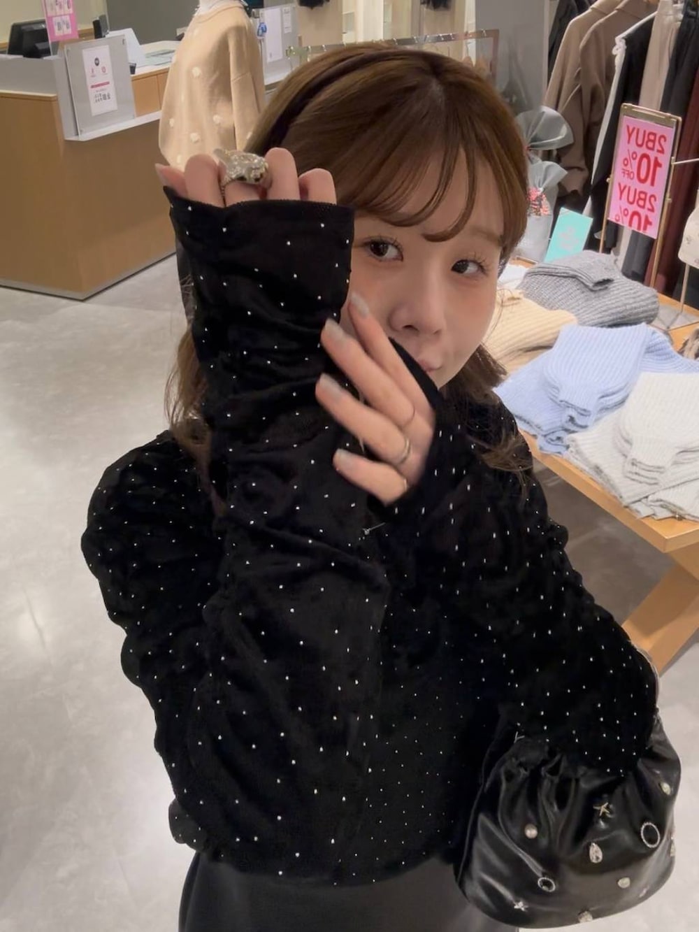 ブラック系のスカート、ブラック系のブーツ、ブラック系のハンドバッグを着用したレディースの冬コーディネートの6枚目の写真