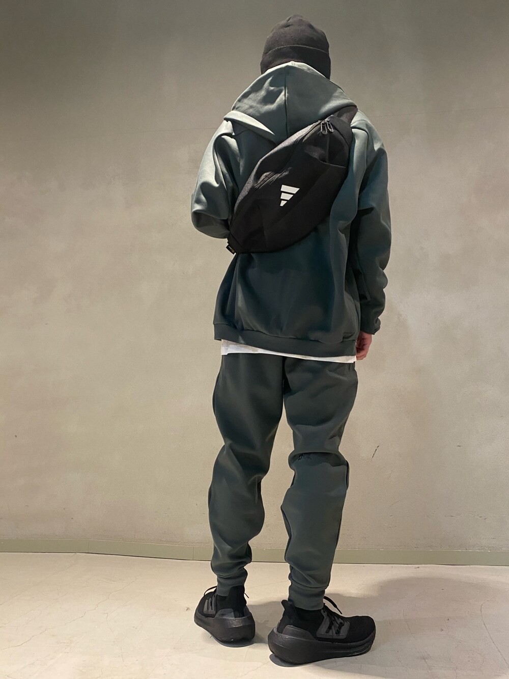 グリーン系のパーカー、グリーン系のその他パンツ、ブラック系のスニーカーを着用したメンズの冬コーディネートの2枚目の写真