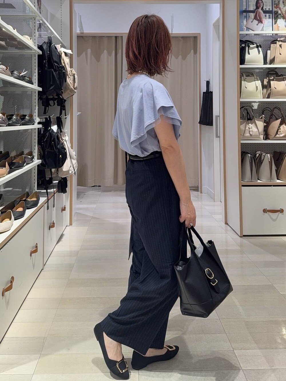 ブラック系のショルダーバッグ、ブラック系のパンプス、ブルー系のその他パンツを着用したレディースの夏コーディネートの6枚目の写真