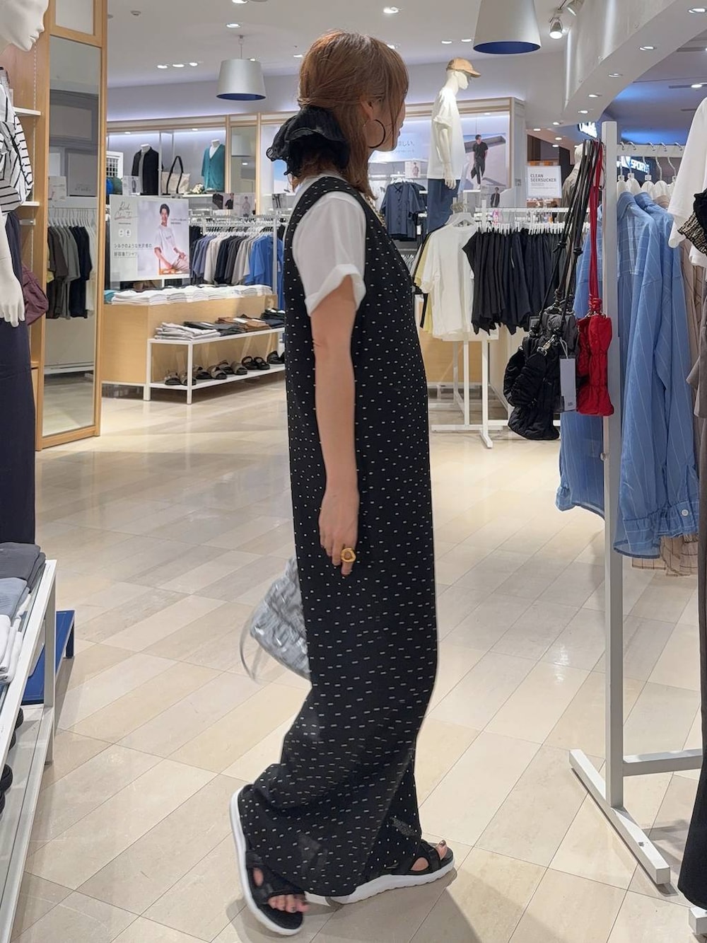 ブラック系のサロペット/オーバーオール、ホワイト系のTシャツ/カットソー、ブラック系のサンダルを着用したレディースの夏コーディネートの4枚目の写真