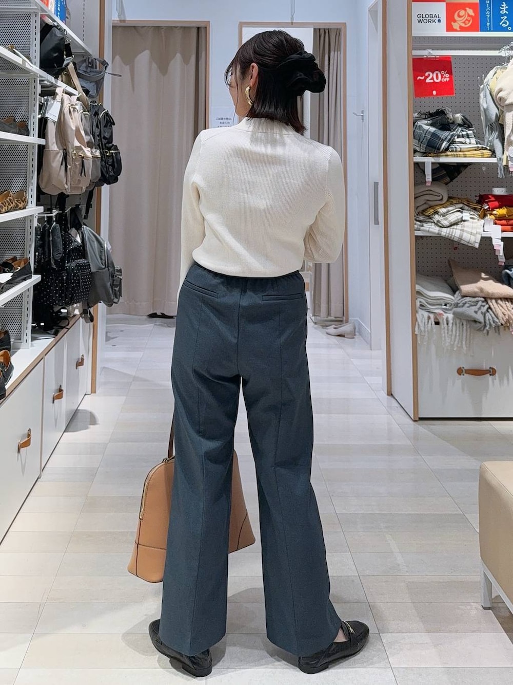 ブラック系のスニーカー、ブラック系のボストンバッグ、ホワイト系のニット/セーターを着用したレディースの冬コーディネートの7枚目の写真