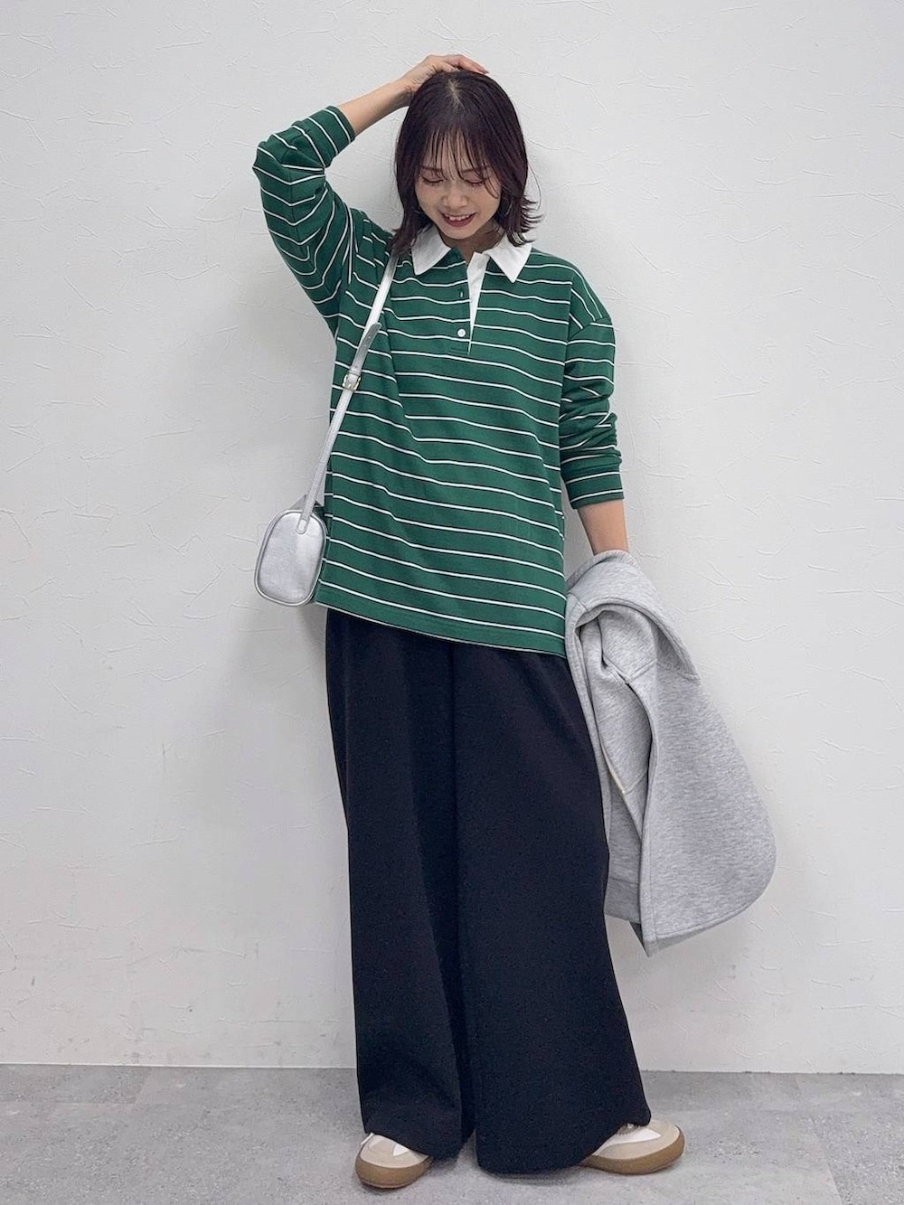 ホワイト系のスニーカー、グレー系のパーカー、ブラック系のスウェットパンツを着用したレディースの冬コーディネートの2枚目の写真