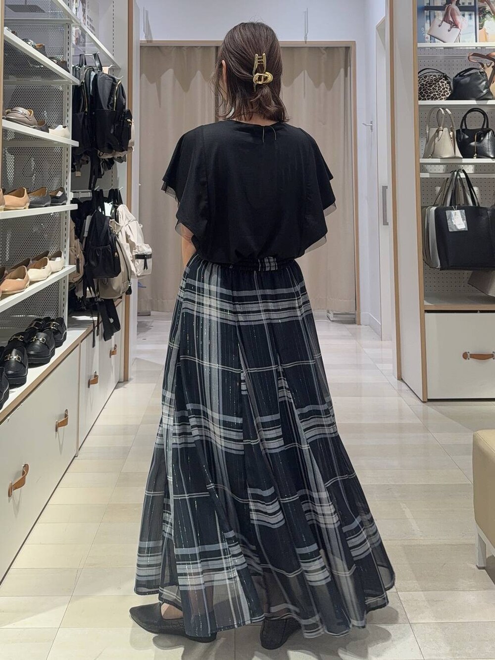 ブルー系のスカート、ホワイト系のショルダーバッグ、ブラック系のTシャツ/カットソーを着用したレディースの夏コーディネートの3枚目の写真