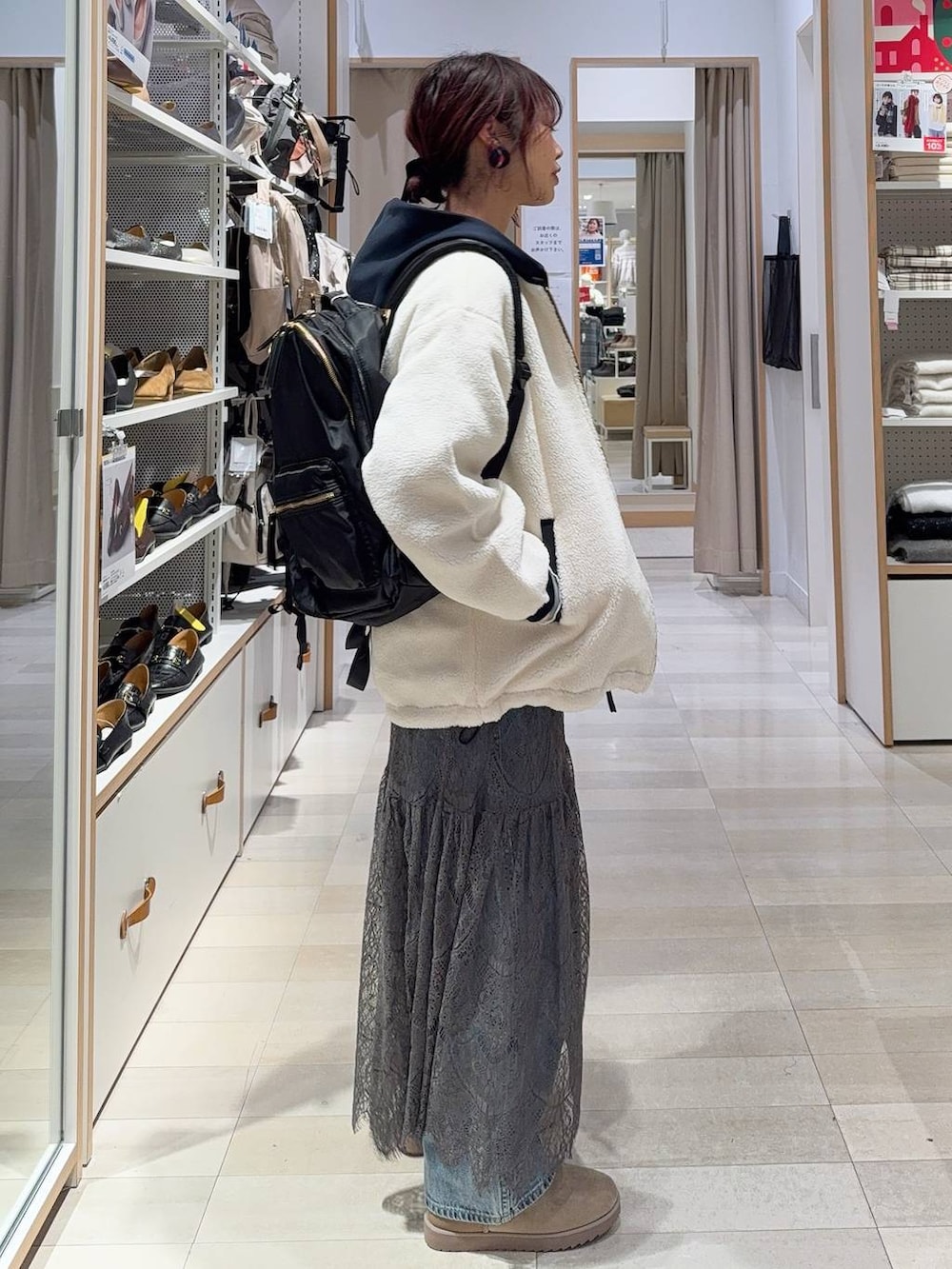 ホワイト系のブルゾン、ブルー系のデニムパンツ、ブラック系のバックパック/リュックを着用したレディースの冬コーディネートの6枚目の写真