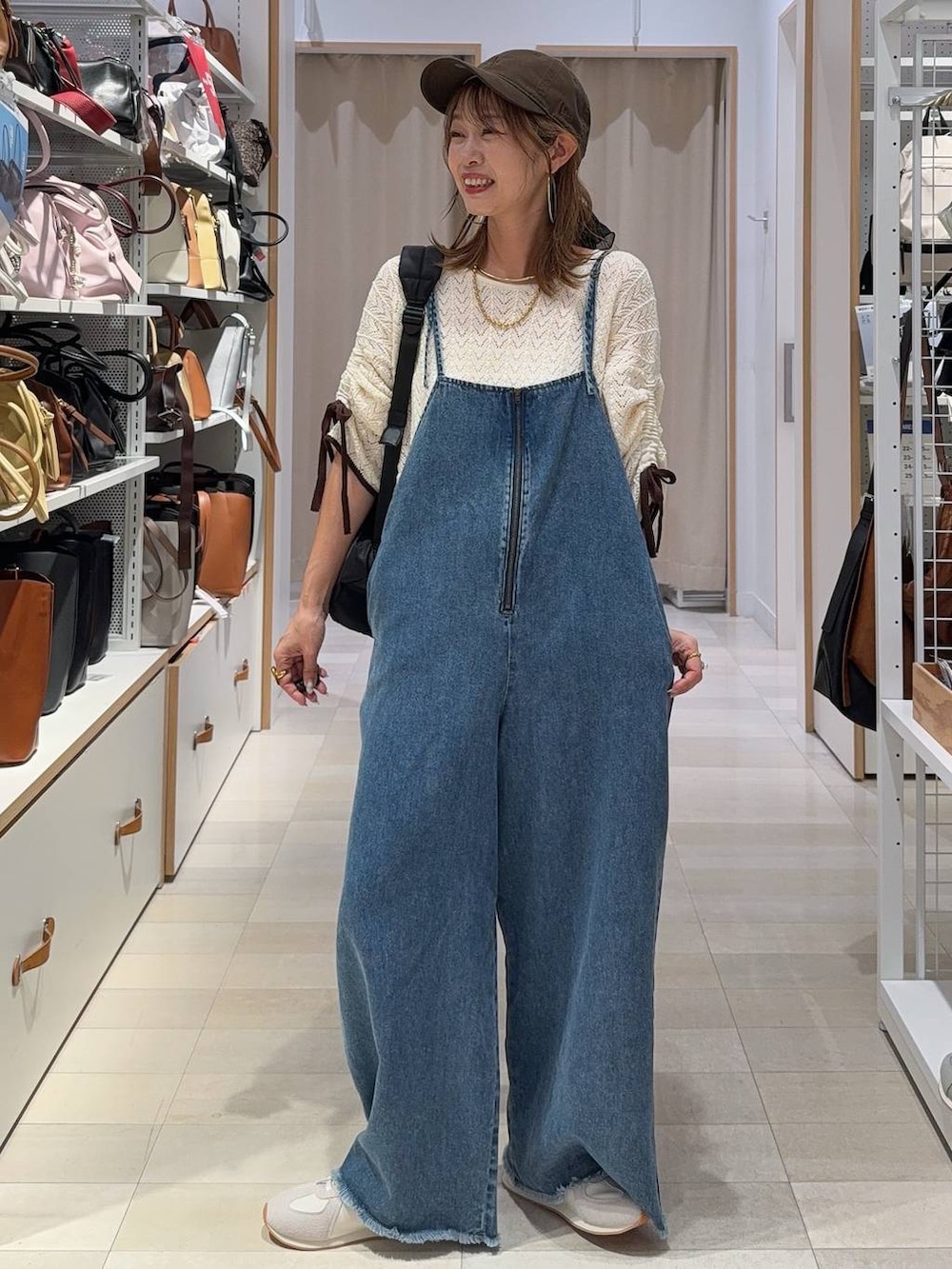 ブラウン系のサンダル、ベージュ系のその他パンツ、ブルー系のデニムパンツを着用したレディースの夏コーディネートの4枚目の写真