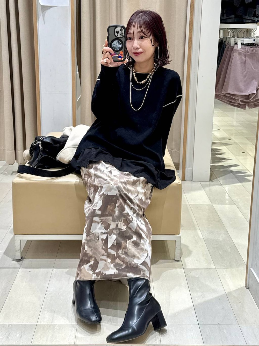 ブラック系のTシャツ/カットソー、ブラック系のワンピース、ブラック系のブーツを着用したレディースの冬コーディネートの3枚目の写真