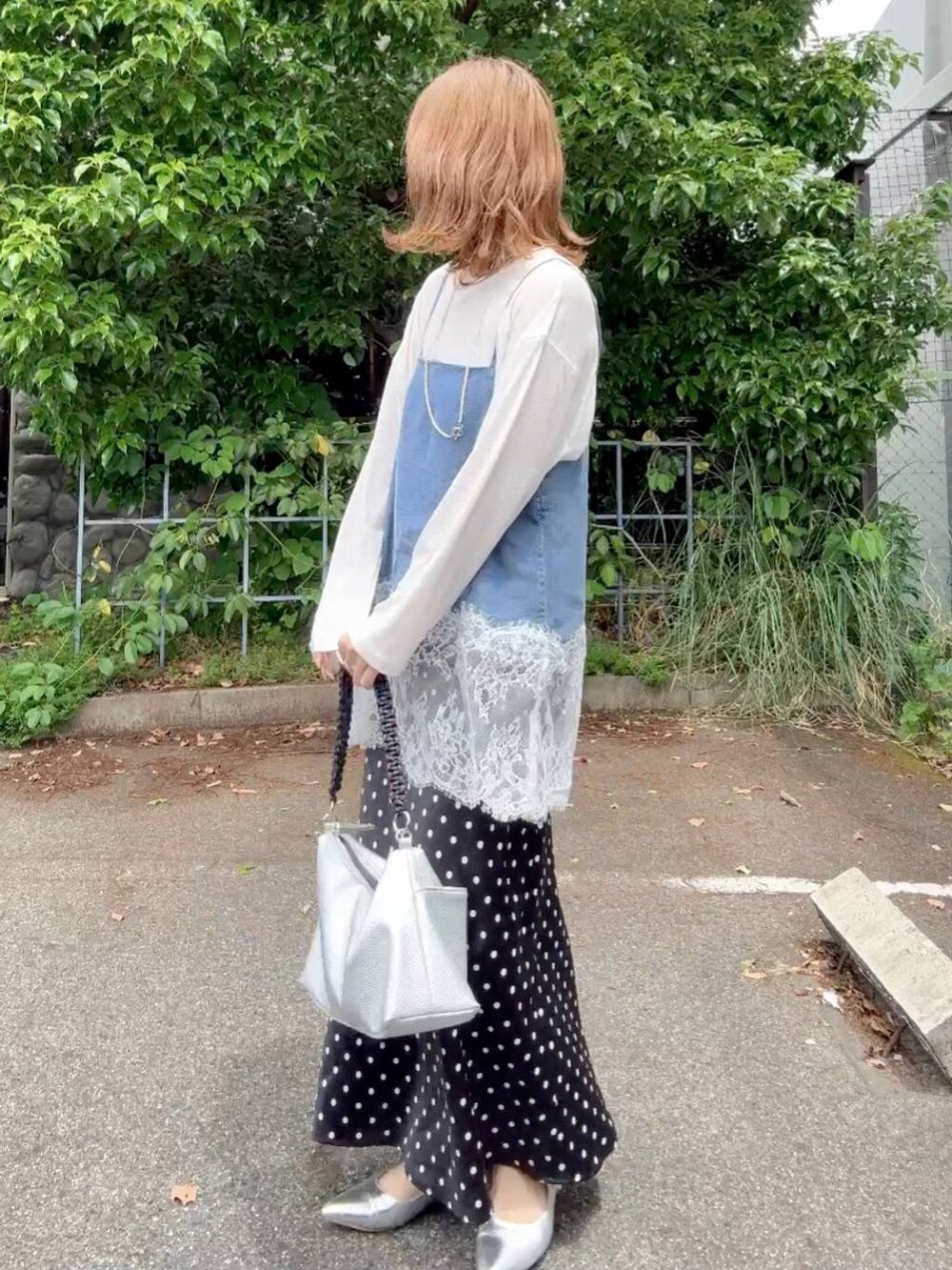 シルバー系のパンプス、ブラック系のスカート、ホワイト系のTシャツ/カットソーを着用したレディースの春コーディネートの2枚目の写真