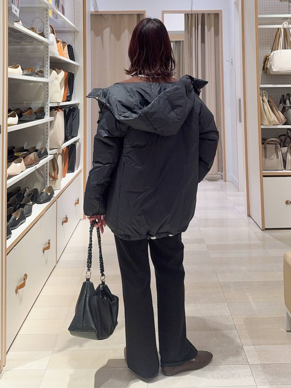 ブルー系のダウンジャケット/コート、ブラウン系のカーディガン/ボレロ、ブラック系のスウェットパンツを着用したレディースの冬コーディネートの4枚目の写真