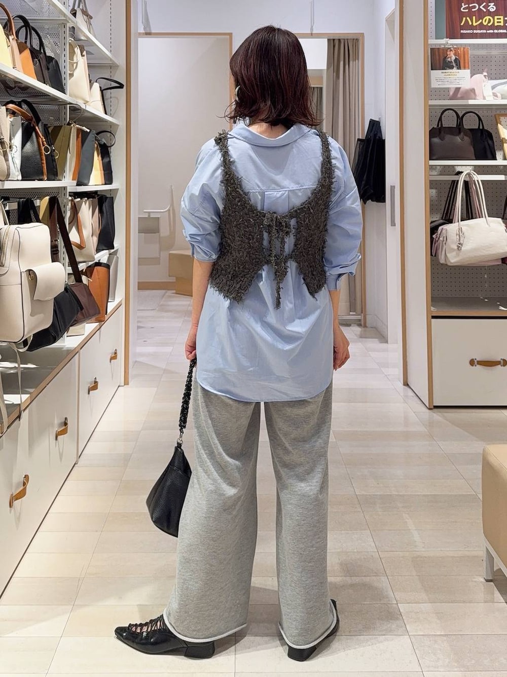 ブルー系のシャツ/ブラウス、グレー系のスウェットパンツ、グレー系のベストを着用したレディースの冬コーディネートの6枚目の写真