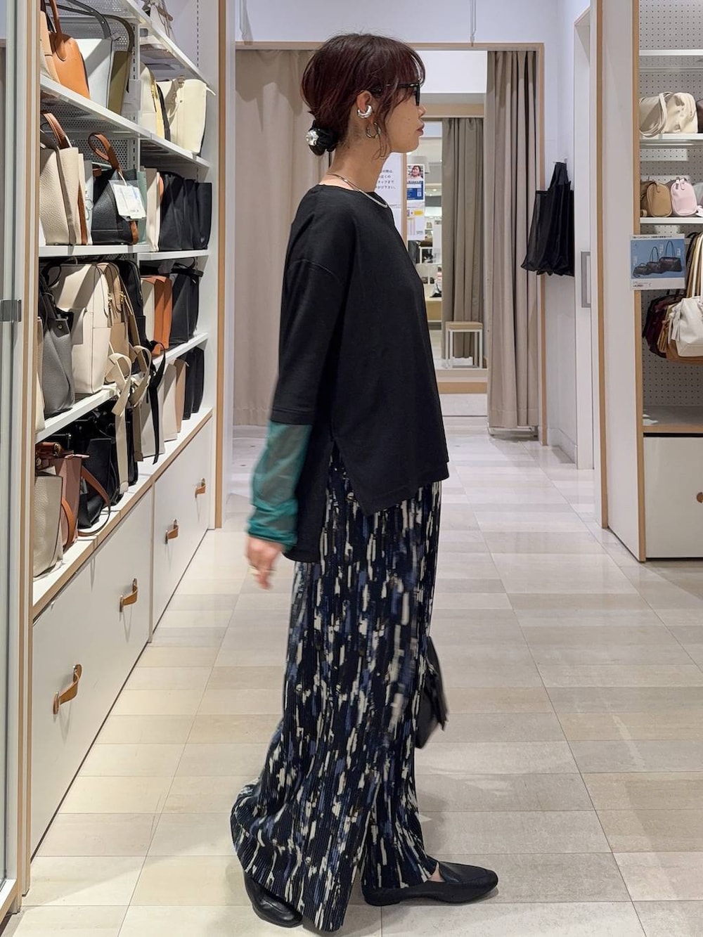 ブラック系のその他シューズ、ブラック系のボストンバッグ、ブルー系のベストを着用したレディースの春コーディネートの6枚目の写真