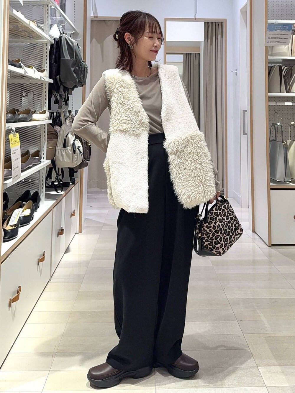 レッド系のスカート、ホワイト系のタンクトップ、ブラック系のハンドバッグを着用したレディースの秋コーディネートの4枚目の写真