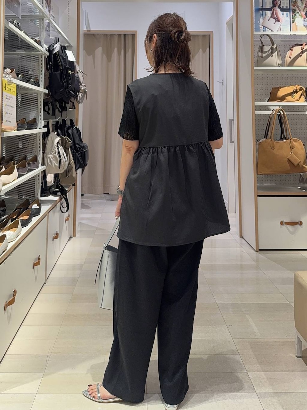 シルバー系のショルダーバッグ、ブラック系のTシャツ/カットソー、シルバー系のサンダルを着用したレディースの夏コーディネートの6枚目の写真