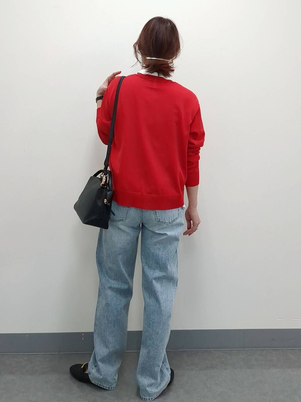 ブラック系のショルダーバッグ、ブラック系のローファー、ブルー系のデニムパンツを着用したレディースの春コーディネートの3枚目の写真