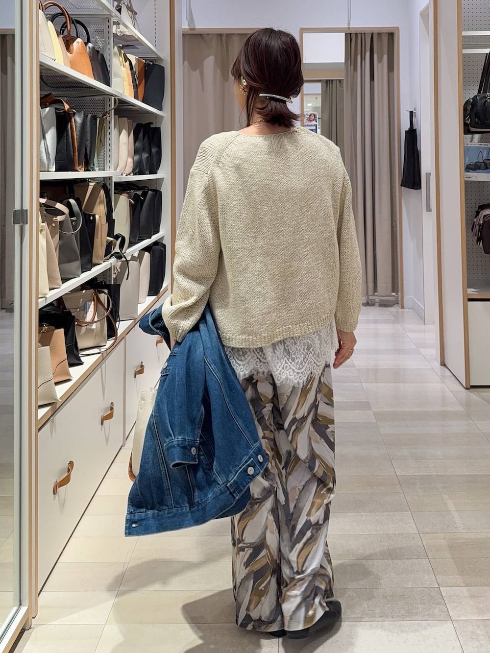 ブラック系のパンプス、ベージュ系のトートバッグ、ブルー系のデニムジャケットを着用したレディースの春コーディネートの6枚目の写真