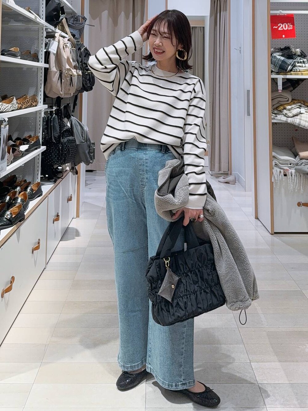 ブラック系のバレエシューズ、グレー系のブルゾン、ブルー系のデニムパンツを着用したレディースの冬コーディネートの3枚目の写真